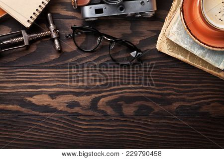 Retro table with vintage items. Old books, glasses, camera, coffee cup and wine corkscrew. Top view with copy space