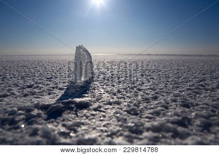 Transparent Icicle At Snowy Frozen Baikal Lake With Blue Sky