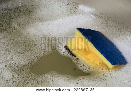 Sponge Close Up In The Sink With Rinse Water.