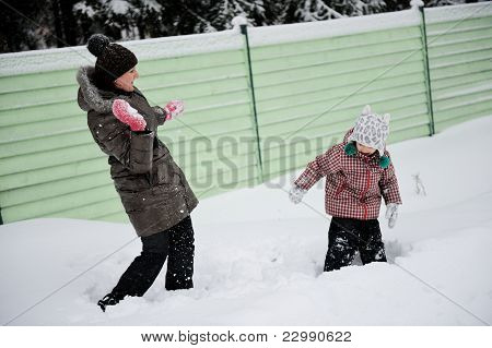Jovem mãe e filha se divertir na neve