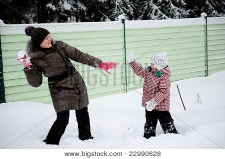 Jovem mãe e filha se divertir na neve