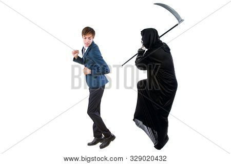 Man In A Halloween Grim Reaper Ghost Costume Chasing, Mocking And Making Fun Of Scared Businessman R