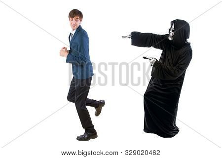 Man In A Halloween Grim Reaper Ghost Costume Chasing, Mocking And Making Fun Of Scared Businessman R
