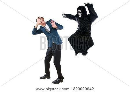 Man In A Halloween Grim Reaper Ghost Costume Chasing, Mocking And Making Fun Of Scared Businessman R