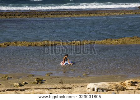 Pinones, Puerto Rico/usa - February 10, 2019: A Small Boy Sits On An Inflatable Tube Decorated With 