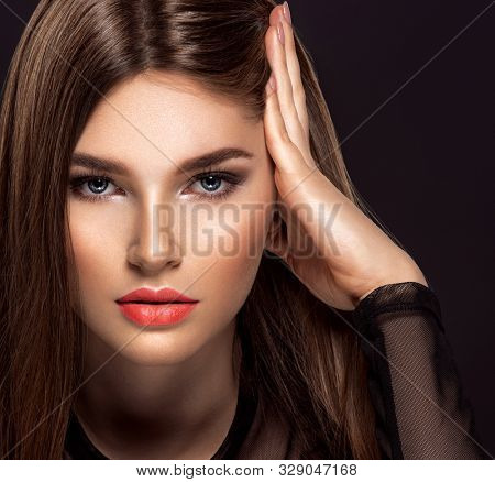 Woman with beauty long brown hair. Fashion model with long straight hair. Fashion model with a smokey makeup. Pretty woman with living coral color lipstick on lips.