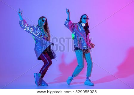 Young Stylish Girls Dancing In The Studio On A Colored Neon Background. Music Dj Poster Design.