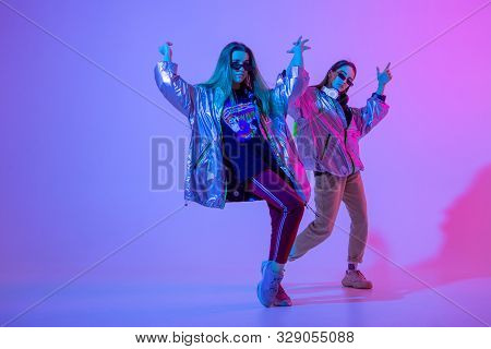 Young Stylish Girls Dancing In The Studio On A Colored Neon Background. Music Dj Poster Design.