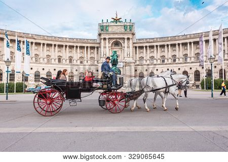 Vienna, Austria - July 12, 2019: Famous Hofburg Palace And Heldenplatz With A Passing Carriage With 