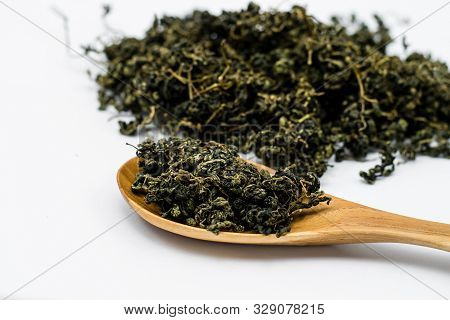 Dry Gynostemma Pentaphyllum Leaf With Wooden Spoon On White Blackground