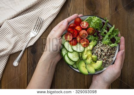 Healthy Food. Womans Hand Holding Budha Bowl With Quinoa, Avocado, Cucumber, Salad, Tomatoe, Olive O