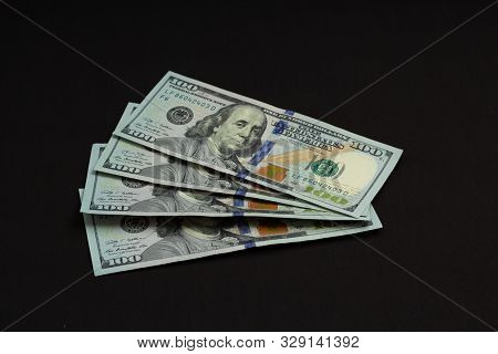 Four Banknotes Four Hundred Us Dollars On A Black Background Tied With A Green Ribbon