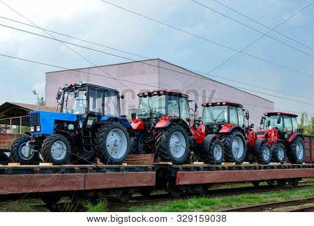 Farm Tractors Loaded On A Freight Train. Import/export Of The Agriculture And Farming Equipment. Log