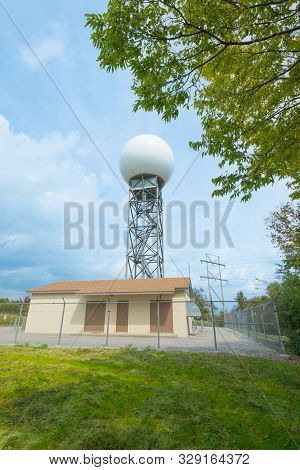 Weather Radar Tower Against Blue Sky With Clouds.