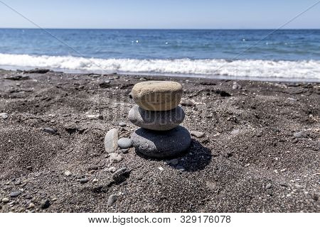 Sea Surf On The Beach With Black Volkanic Sand And Stones.