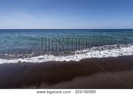 Sea Surf On The Beach With Black Volkanic Sand.