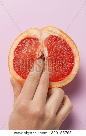 Two Female Fingers In Grapefruit, Woman Masturbation And Sex Concept. Vagina And Clitoris Symbol.