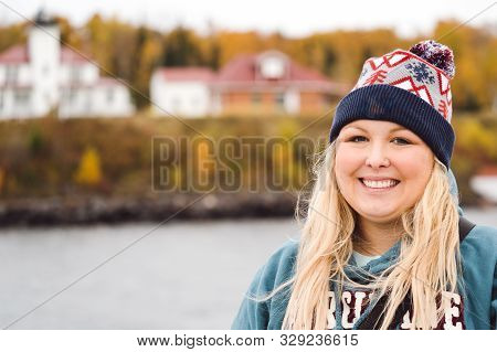 Woman Tourist Poses For A Photo Near The Rasperry Island Lighthouse While On A Boat Cruise Of The Ap