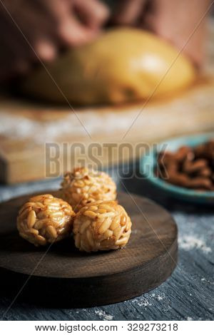 closeup of a young caucasian man preparing some panellets, sweet food typically eaten in All Saints Day in Catalonia, Spain