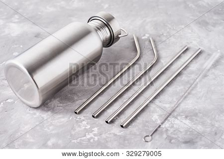 Reusable Plastic Free Items On Gray Background. Top View Of Aluminun Bottle And Metal Tubes. Zero Wa
