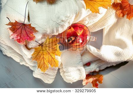 Hot grog, warm sweater and autumn leaves