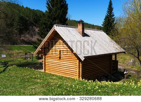 New Log-house Made By Old Technologies In A Green Meadow By The River. Beautiful Natural Background,