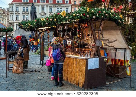 PRAGUE, CZECH REPUBLIC - DECEMBER 12, 2016: People stand near stall with craft souvenirs during famous traditional Christmas market taking place each year in Old Town of Prage