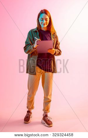 Modern Girl With Laptop, Tablet Computer. Free Creativity. A Young Blogger Makes A Home Office. Colo