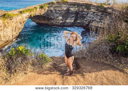 Young Woman Tourist Near Broken Beach In Nusa Penida, Indonesia Angels Billabong Beach. Popular Tour