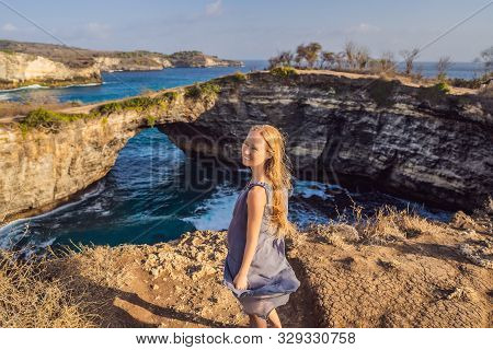 Young Woman Tourist Near Broken Beach In Nusa Penida, Indonesia Angels Billabong Beach. Popular Tour
