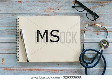 Top View Of Pen,glasses,stethoscope And Notebook Written With Ms Or Multiple Sclerosis On Wooden Bac