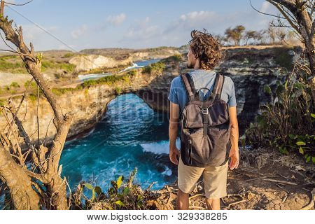 Young Man Tourist Near Broken Beach In Nusa Penida, Indonesia Angels Billabong Beach. Popular Touris