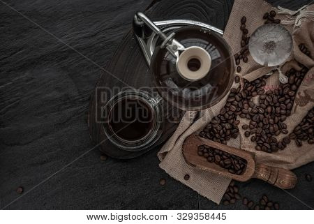 Coffee Style, Cup Of Coffee And Coffee Beans Roating With Old Wooden Scoop And Coffee Beans Around O
