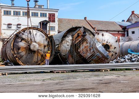 Zrenjanin, Vojvodina, Serbia - June 08, 2018: Crane Is Bringing Down Heavy Metal Silo In Industrial 