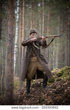 A Soldier Of World War Ii Is Holding The Rifle In His Hands And Aiming