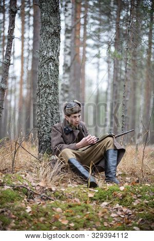 A Soldier Of World War Ii Is Sitting In The Forest