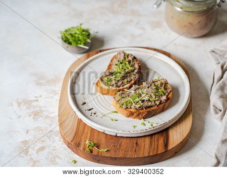 Two Toasts Chicken Rillettes (pate) On White Bread With Sprouts On White Plate On Wood Cutting Board