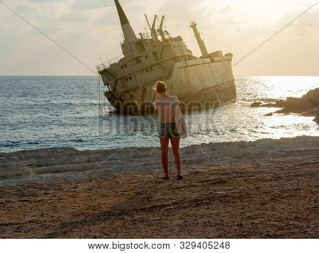 Silhouette Of Girl Taking A Photo On Sunset. Old Ship On The Mediterranean Sea Background. The Old E