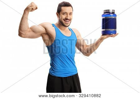 Young bodybuilder holding a pack of protein powder and flexing bicep muscle isolated on white background