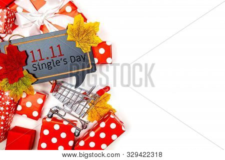 Online Shopping Of China, 11.11 Single's Day Sale Concept. The Shopping Cart, White Ribbon And Red G
