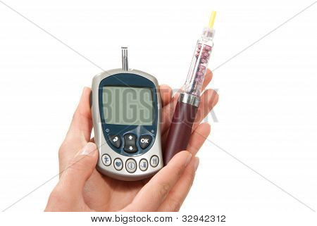 Manos con inyector de pluma jeringa y glucómetro
