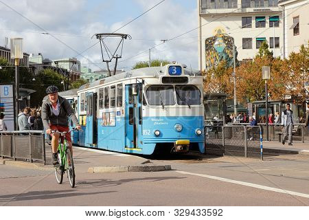 Gothenburg, Sweden - September 2, 2019: Male Cyclist And Tram Of Class M29 At The Tram Stop Kungspor
