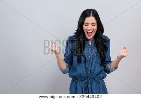 Young Woman Making A Yay Gesture On A Gray Background