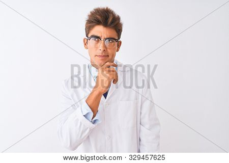 Young handsome sciencist man wearing glasses and coat over isolated white background Thinking worried about a question, concerned and nervous with hand on chin