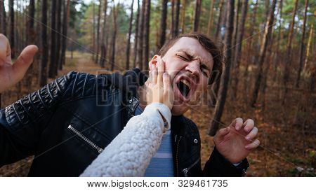 A Womans Hand Hits A Mans Face In The Autumn Forest. An Emotional Male Is Getting Slapped In Face, W