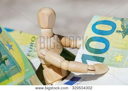Wooden Dummy Puppet Holding Hundredth Euro Banknotes. Money Or Business Concept. Abstract Conceptual