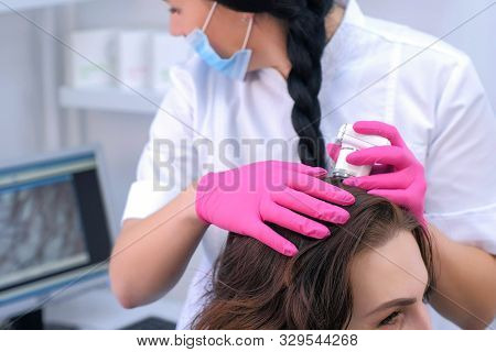 Doctor Trichologist Examines Woman Patients Hairs Using Trichoscope In Clinic. Procedure Of Trichosc