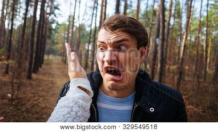 A Womans Hand Hits A Mans Face In The Autumn Forest. An Emotional Male Is Getting Slapped In Face, W