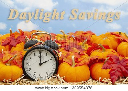 Daylight Savings Time Change Message With A Retro Alarm Clock With Orange Pumpkins With Fall Leaves 