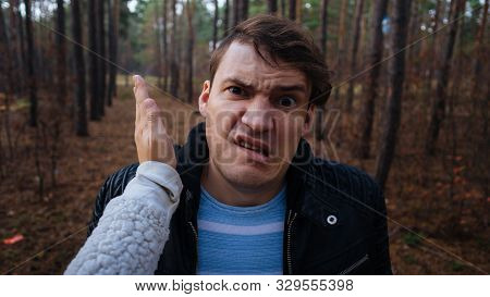 A Womans Hand Hits A Mans Face In The Autumn Forest. An Emotional Male Is Getting Slapped In Face, W